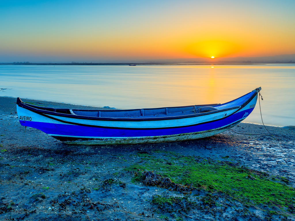 Лодка на берегу реки на закате солнца