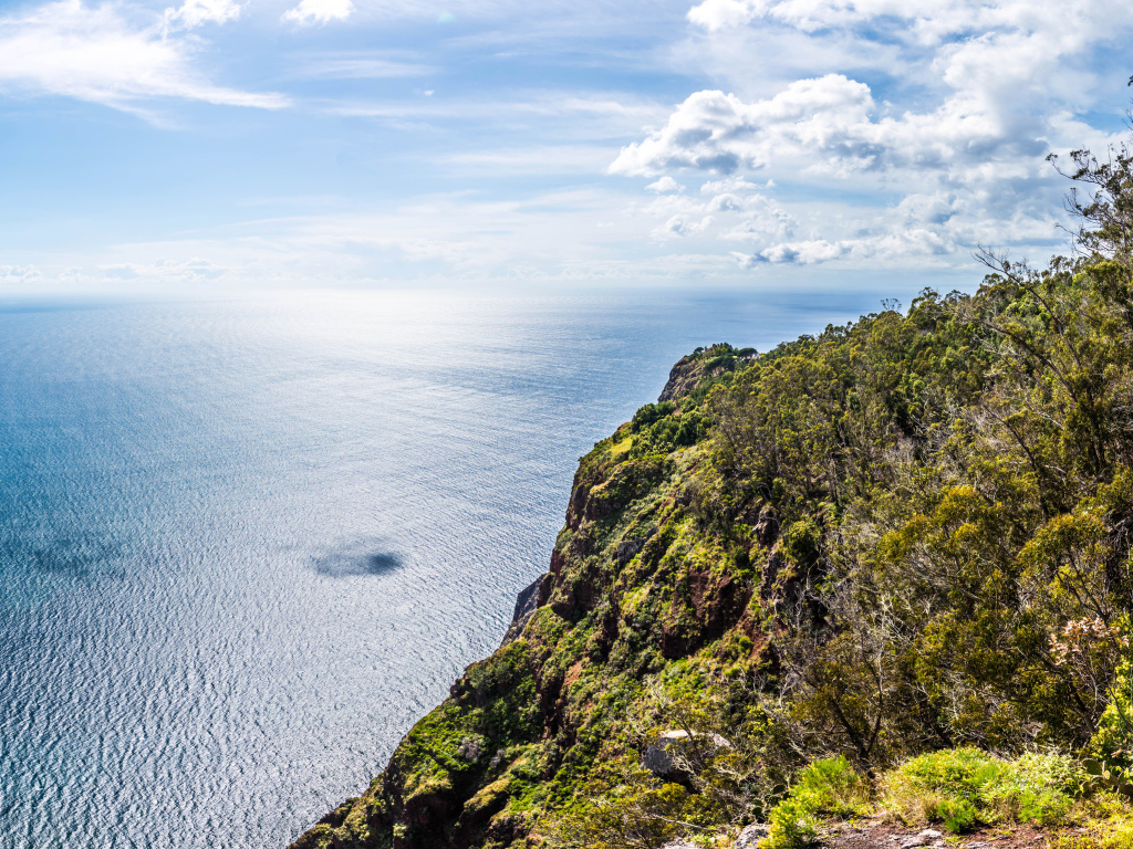 Утес на берегу океана на фоне красивого голубого неба