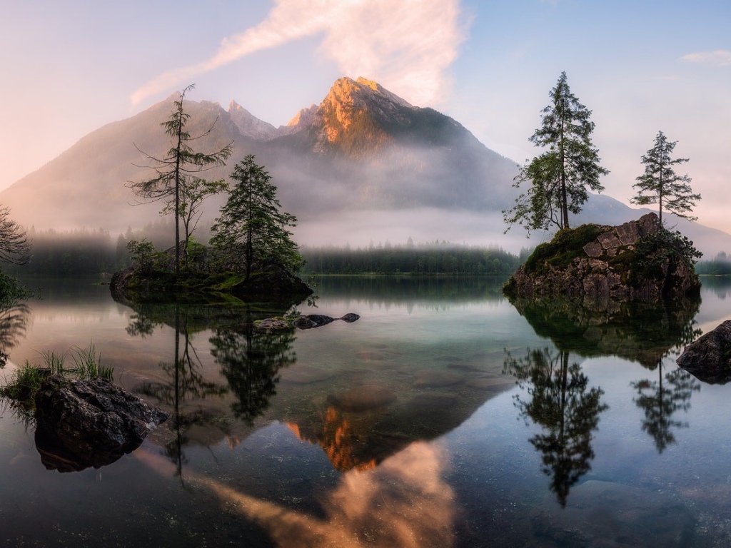 Горное озеро у покрытых туманом гор 