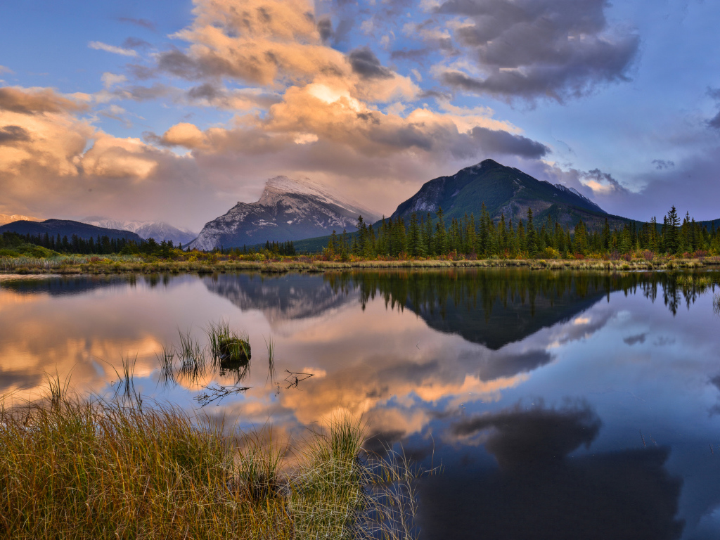 Небо и горы отражаются в чистой воде озера 
