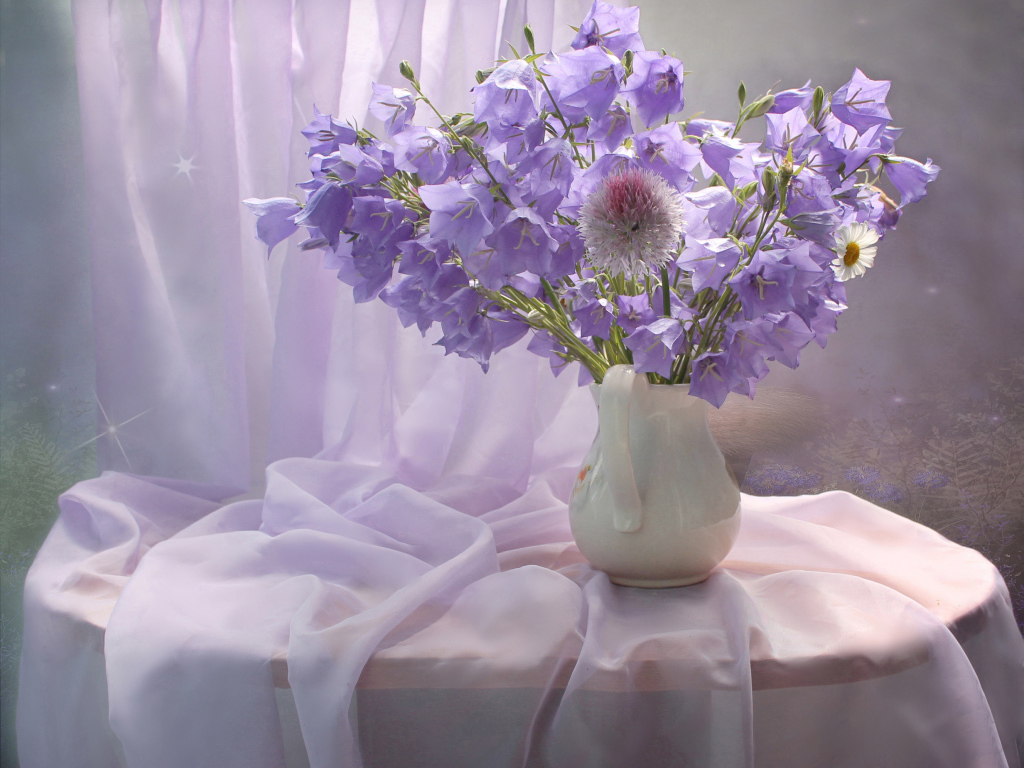 Букет фиолетовых колокольчиком в белой вазе на столе