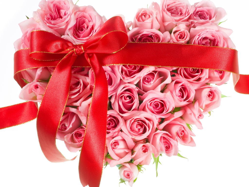 Сердце из розовых роз с красной лентой на белом фоне