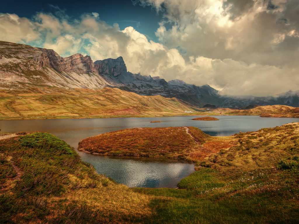 Горы под белыми облаками у озера в Швейцарии