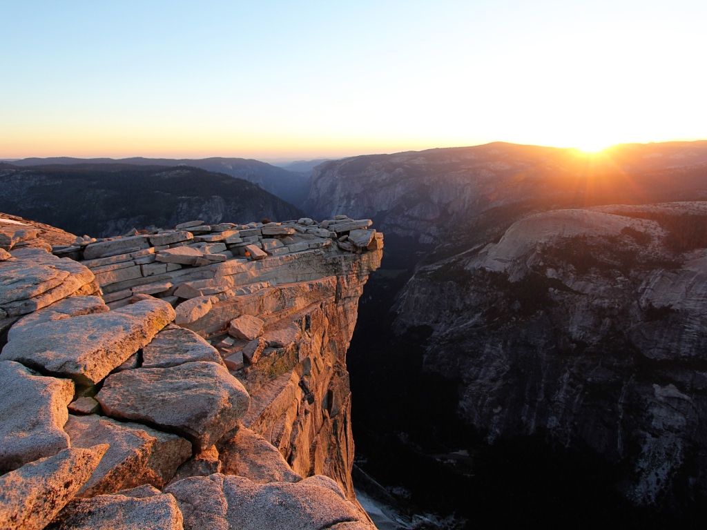 Каменные горы на фоне солнца на закате