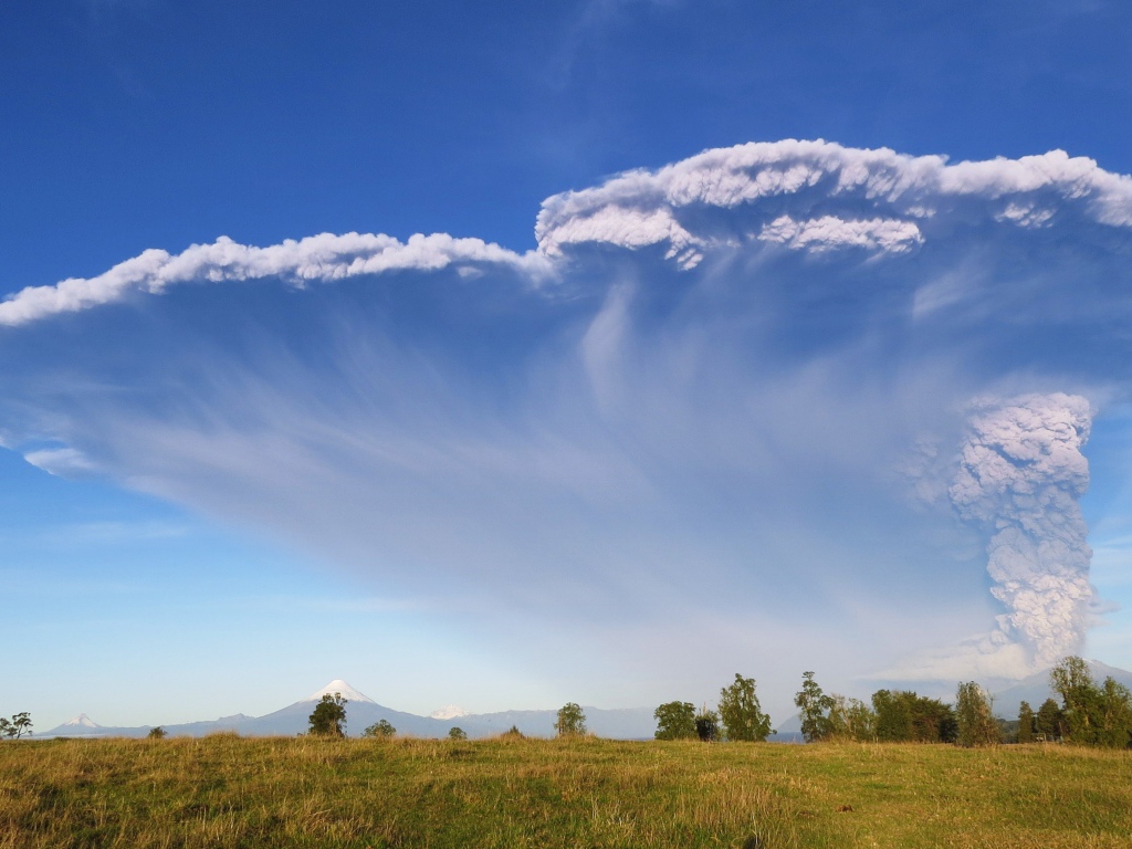 Белый дым активного вулкана Кальбуко в голубом небе, Чили