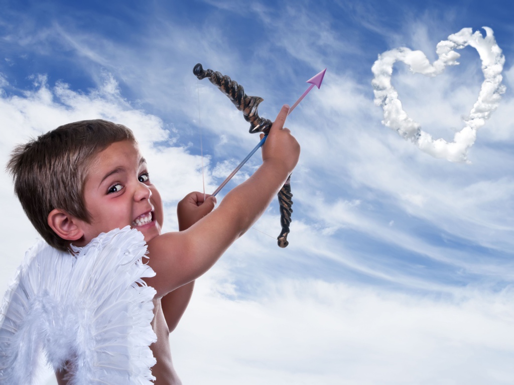 Мальчик в костюме купидона пускает стрелу в небо