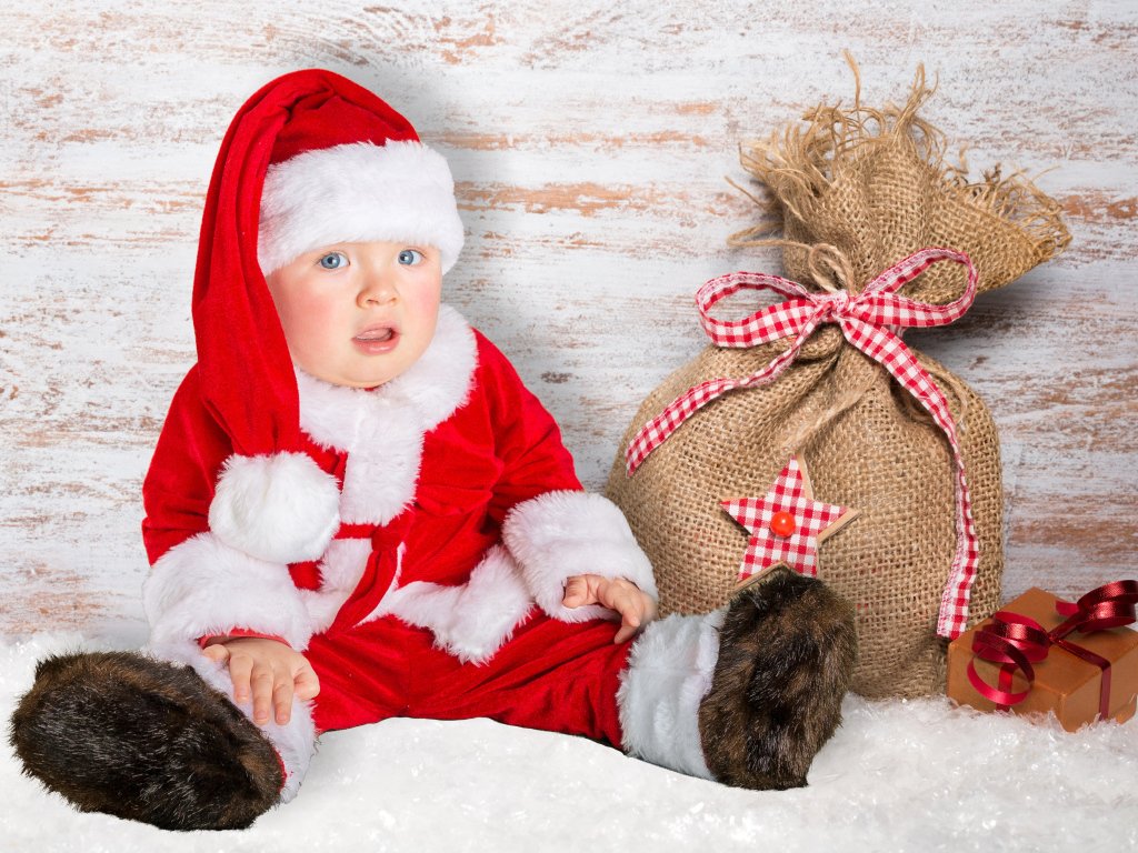 Маленький ребенок в костюме Санты с мешком