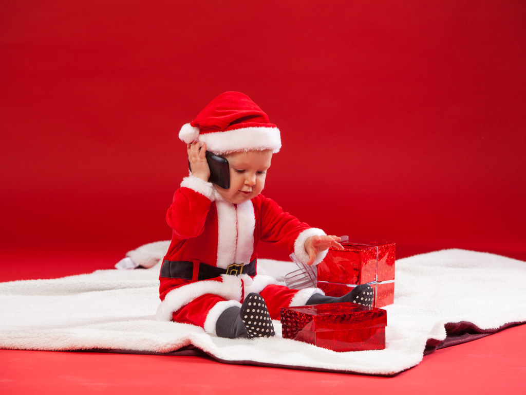 Маленький ребенок в новогодней униформе с подарками