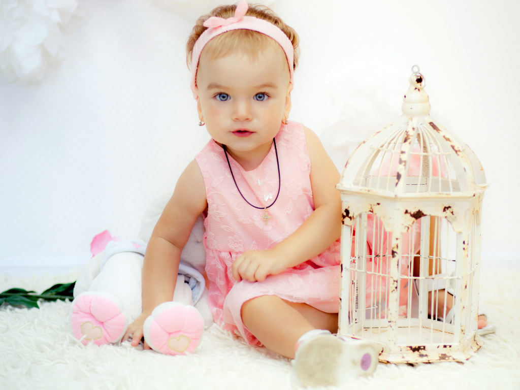 Красивая маленькая девочка в розовом платье с клеткой