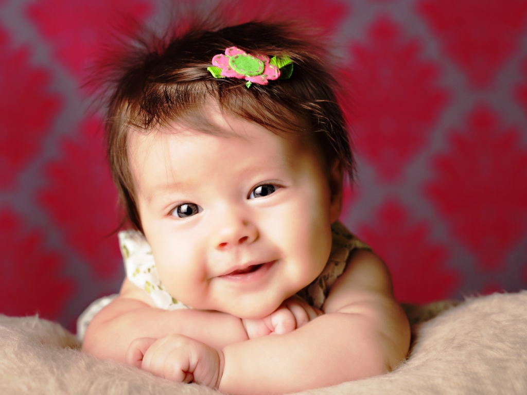 Милая маленькая девочка с цветком в волосах 