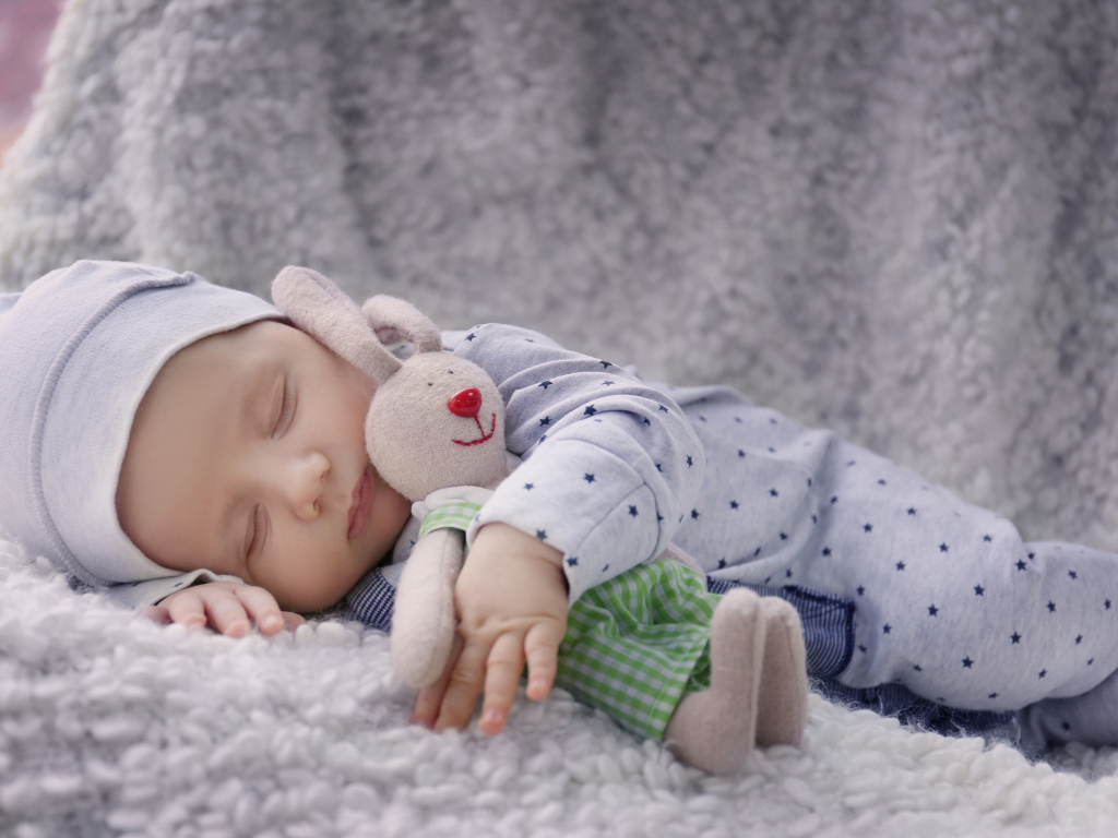 Милый спящий ребенок с игрушкой