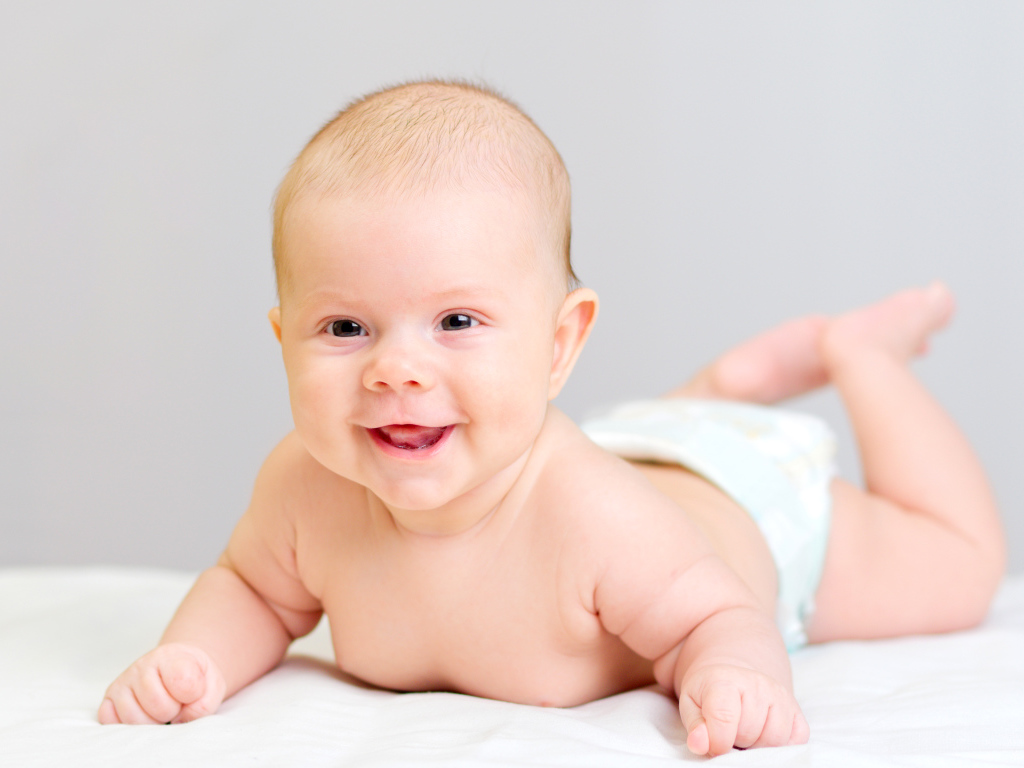 Милый улыбающийся ребенок на сером фоне