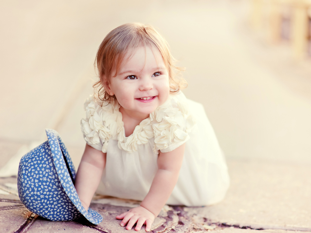 Милая улыбающаяся девочка в белом платье