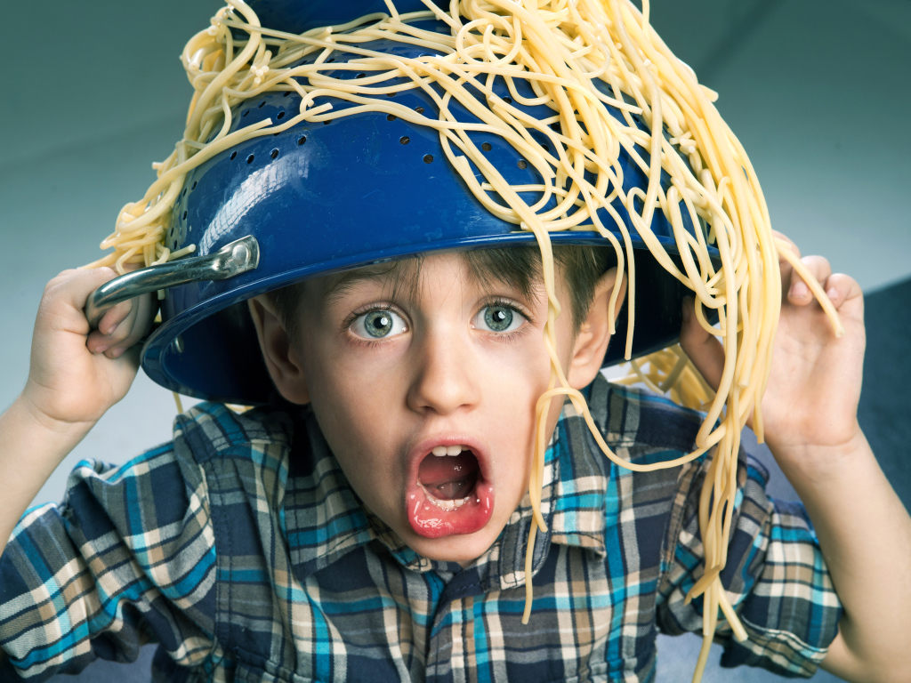 Смешной мальчик со спагетти на голове
