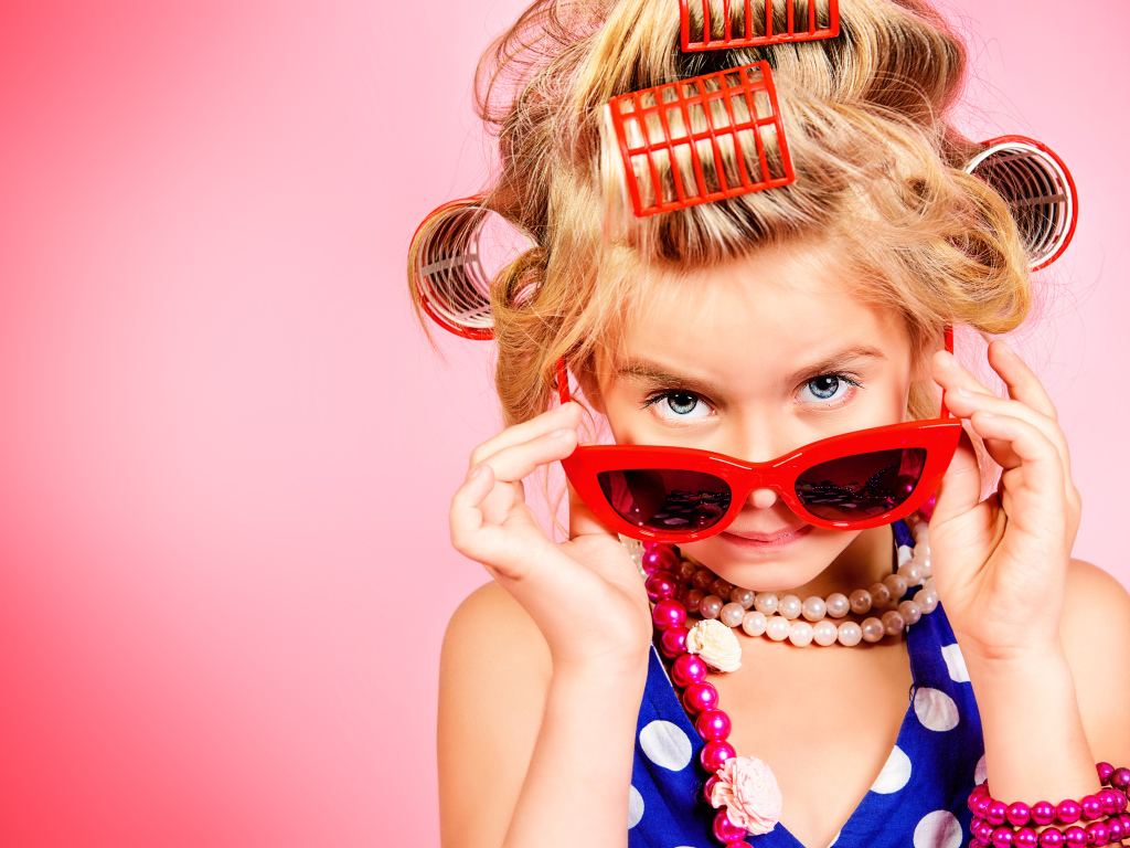 Гламурная девочка в больших красных очках и бигудями на голове