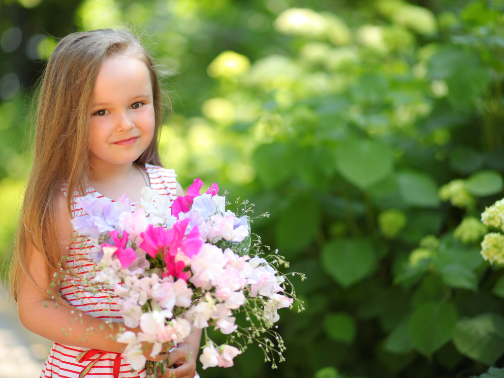Русоволосая девочка с букетом цветов в руках