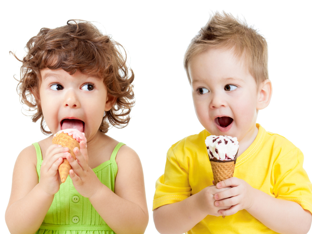 Маленькие мальчик и девочка едят вкусное мороженое