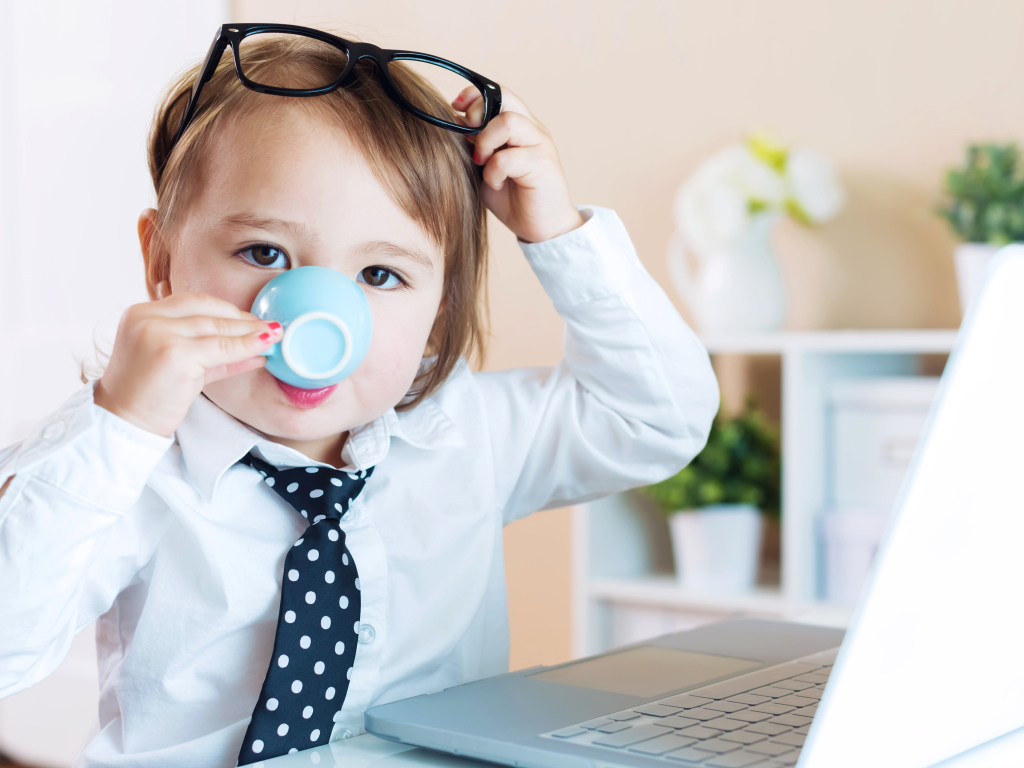 Маленький мальчик в деловом костюме и с чашкой