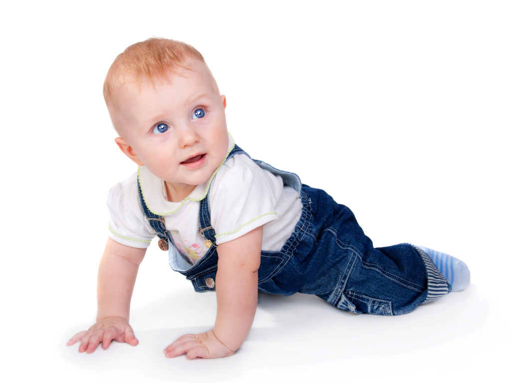 Маленький мальчик в синем комбинезоне на белом фоне