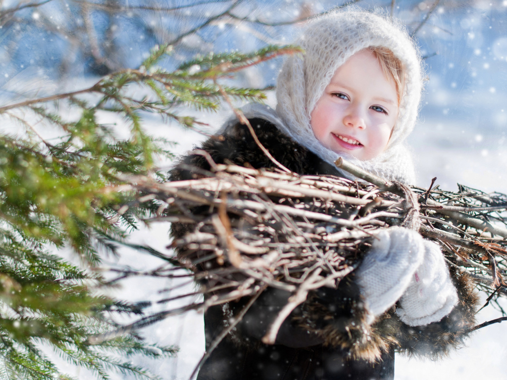Маленькая девочка с пучком хвороста зимой