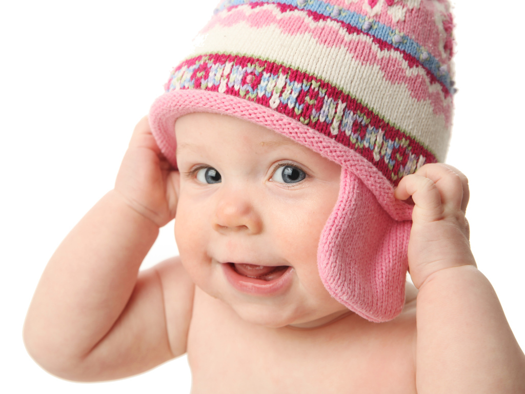 Улыбающийся ребенок в шапке на белом фоне