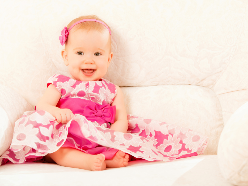 Улыбающаяся маленькая девочка в красивом розовом платье