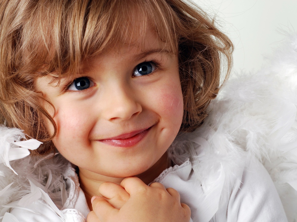 Маленькая голубоглазая девочка в костюме ангела 