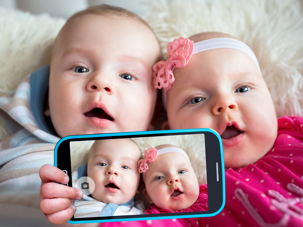 Два маленьких ребенка делают селфи на телефон