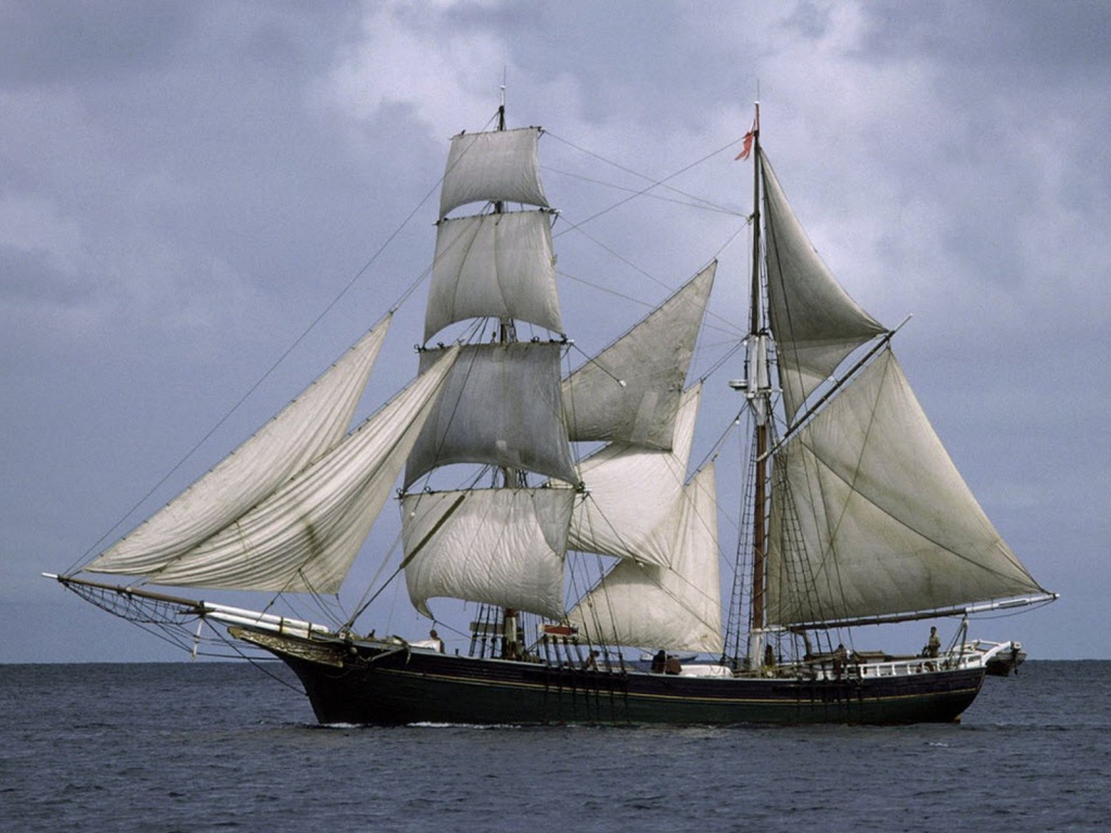 Корабль с белыми парусами в море 