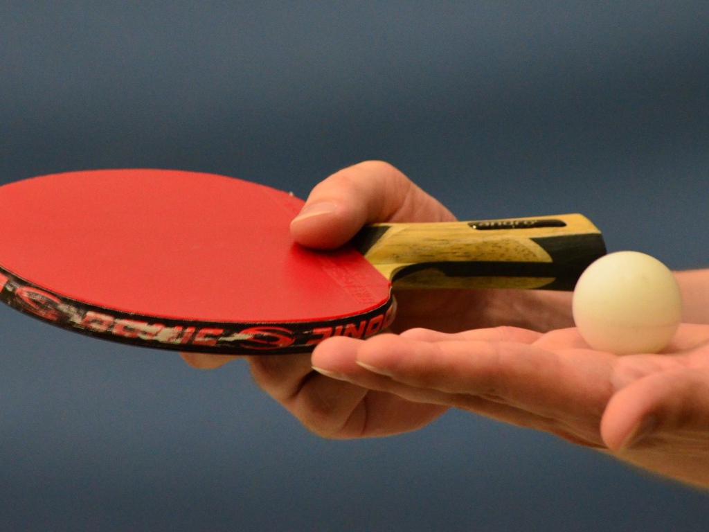 Ракетка для настольного тенниса и мяч в руке 