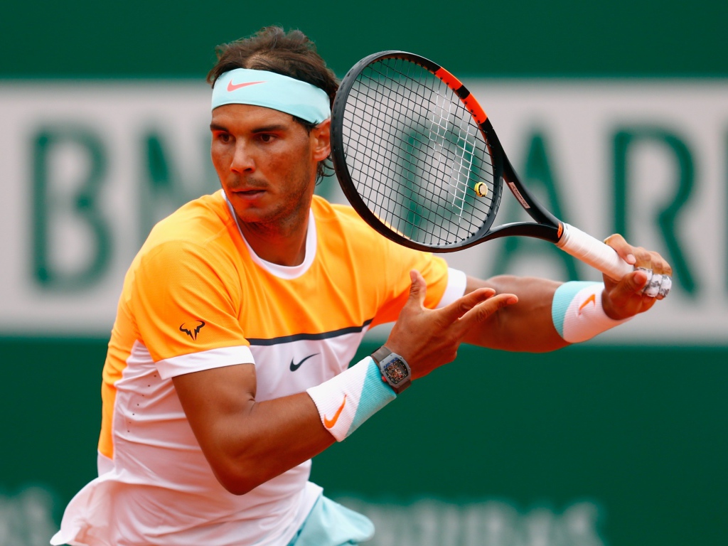 Теннисист Рафаэль Надаль с ракеткой на корте 