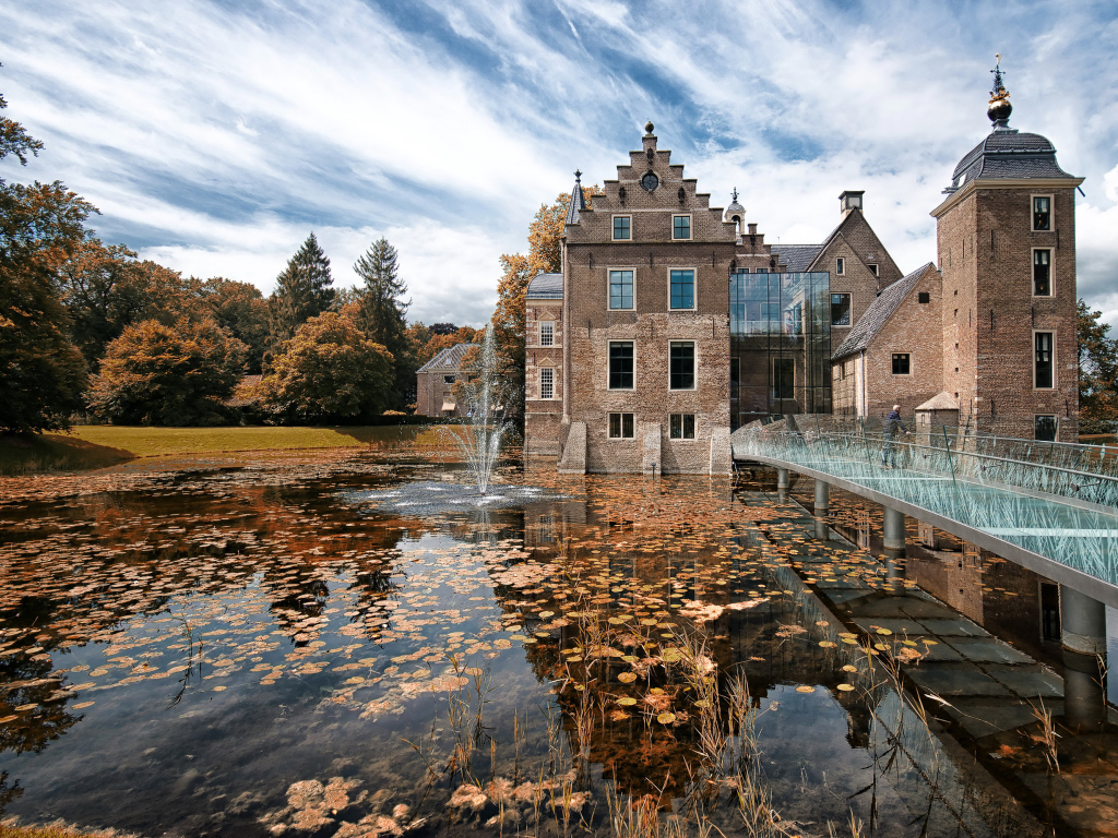 Замок Huis te Ruurlo у воды под красивым небом, Нидерланды