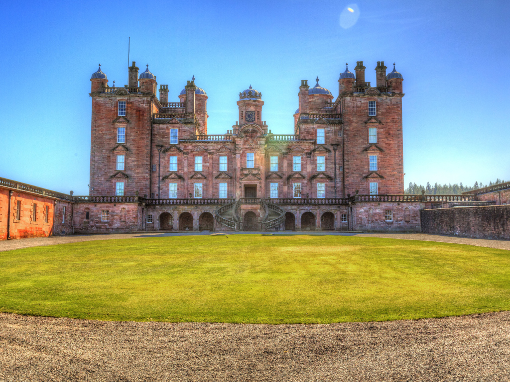 Замок Drumlanrig Castle с зеленым  газоном, Шотландия 