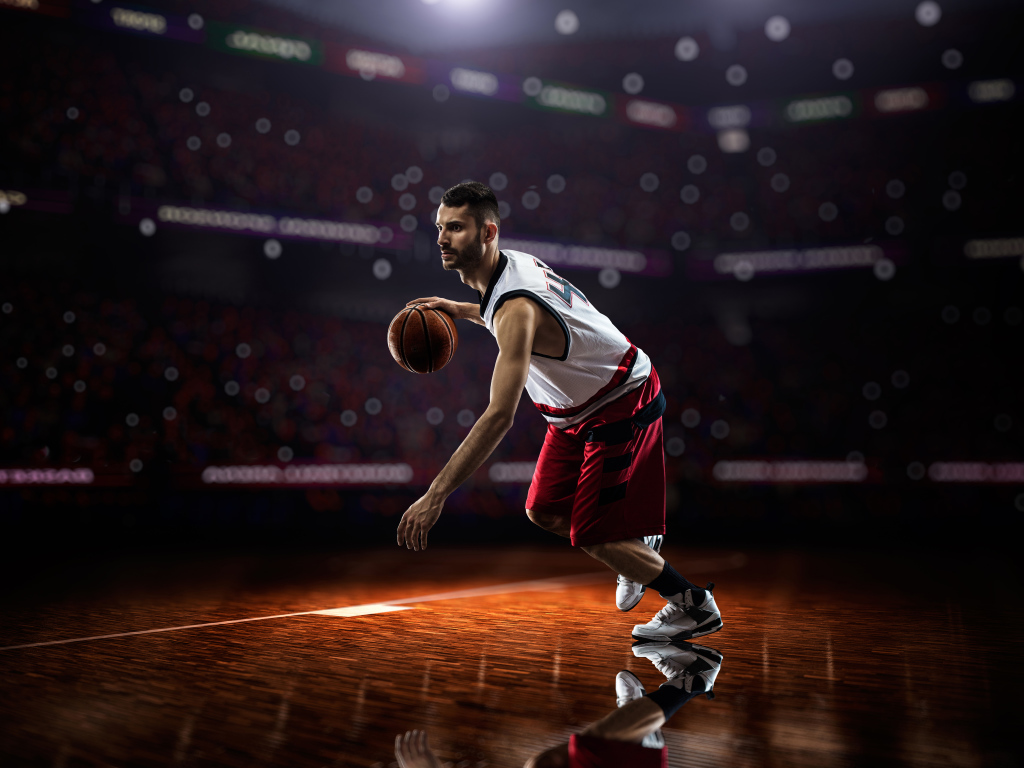 Баскетболист с мячом играет на поле