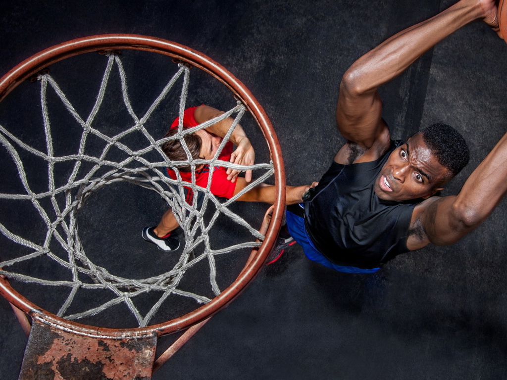 Баскетболист забрасывает мяч в кольцо 