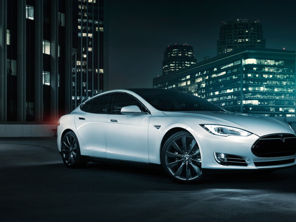 Белый электромобиль Тесла на фоне города 