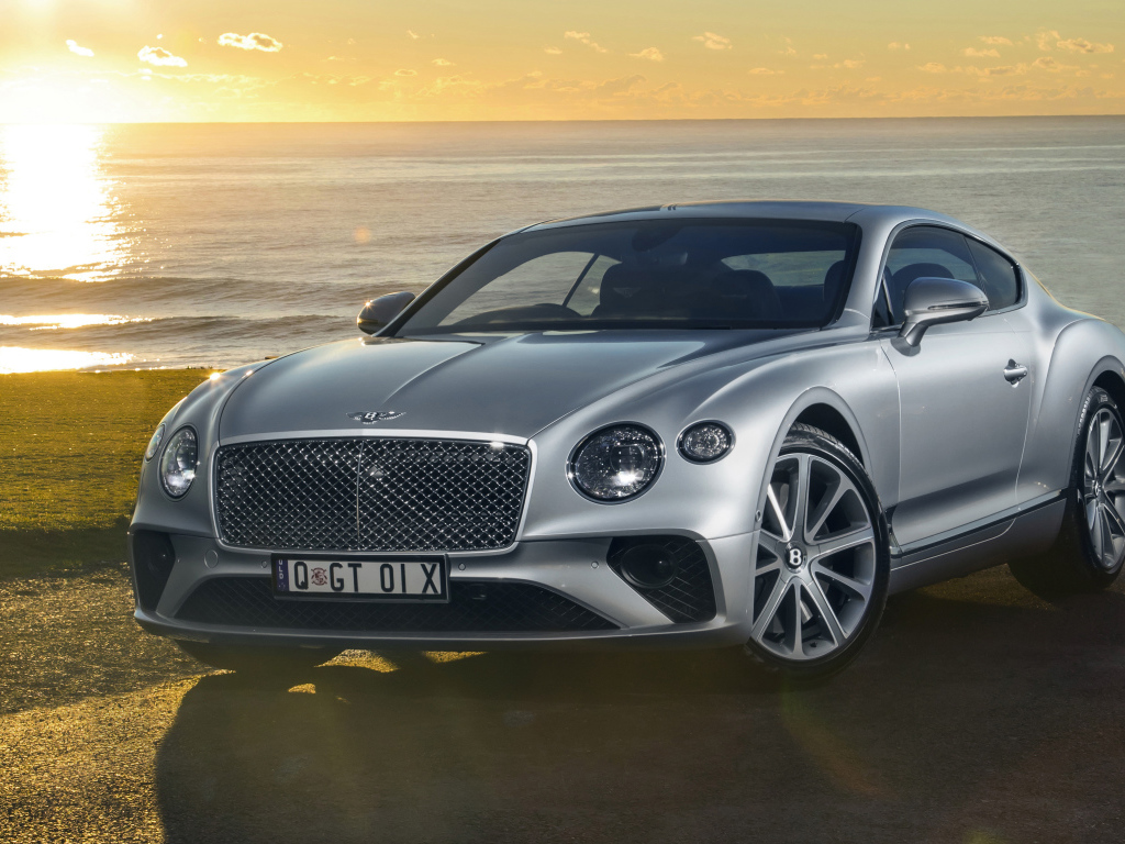 Серебристый Bentley Continental GT 2018 года на фоне моря