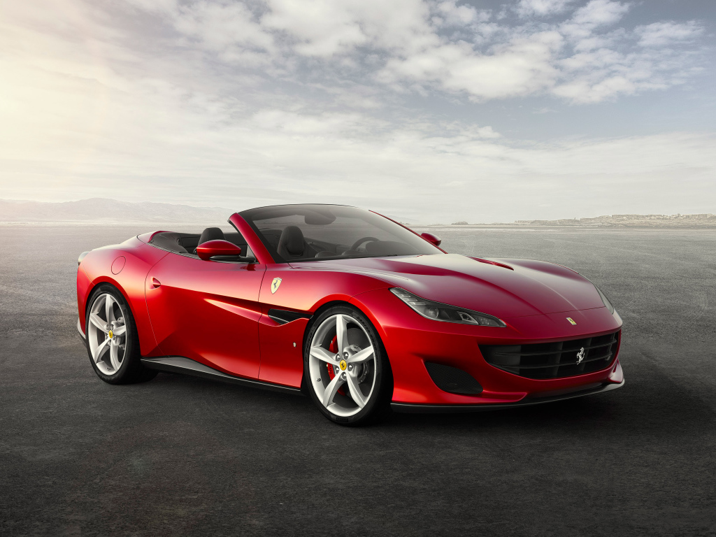 Красный автомобиль кабриолет Ferrari Portofino на фоне неба