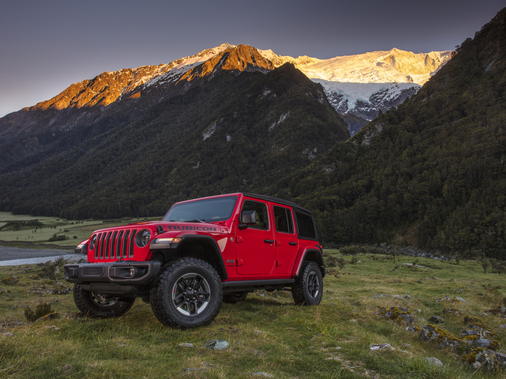 Красный автомобиль Jeep Wrangler на фоне гор