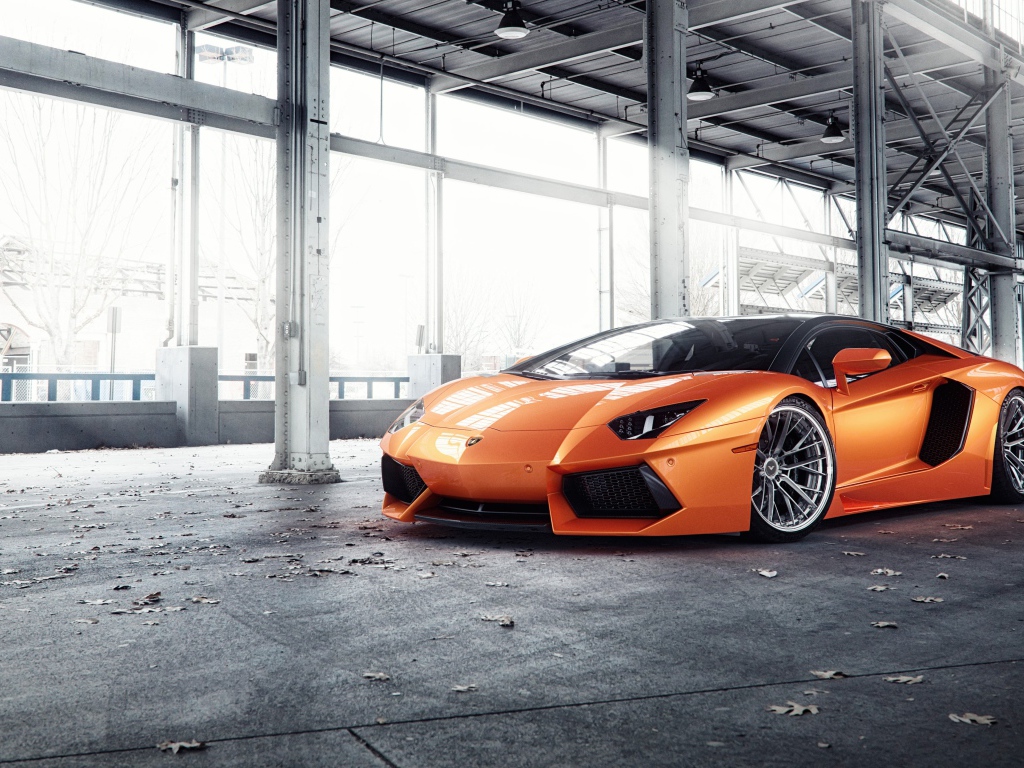 Оранжевый автомобиль Lamborghini Aventador под мостом