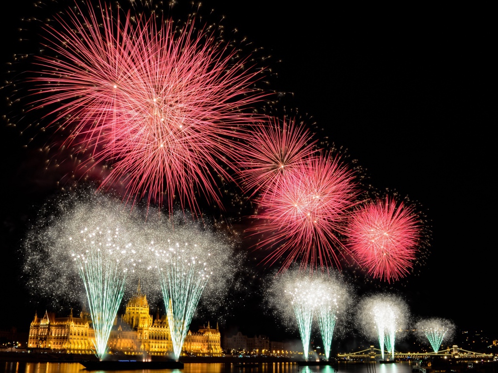 Взрывы яркого салюта над ночным городом 