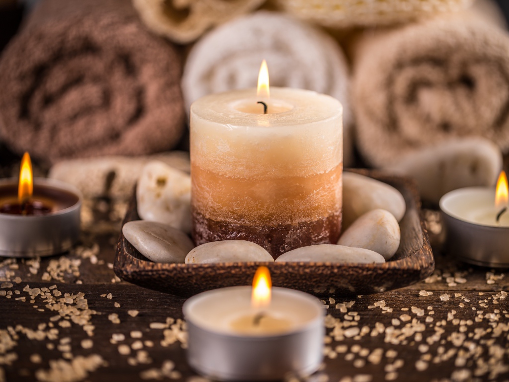 Зажженная свеча с камнями для SPA процедур