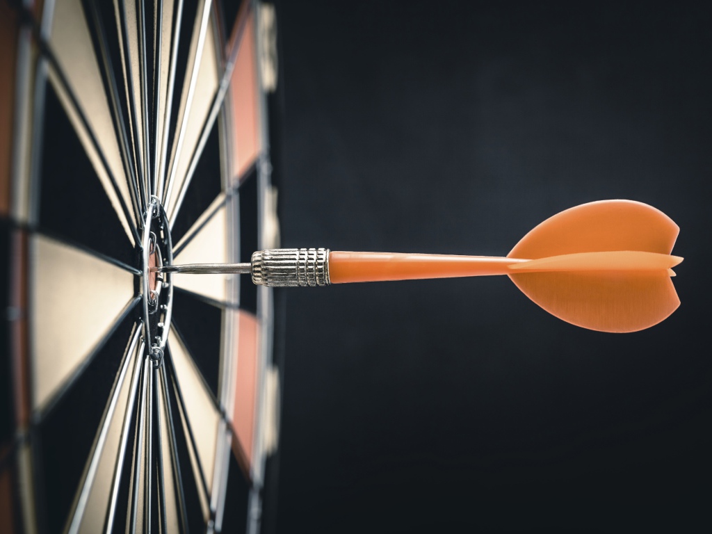 Оранжевый дротик в доске для дартса 