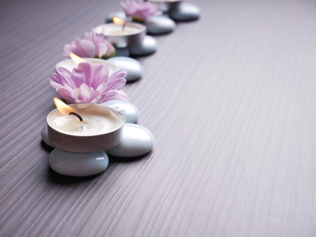 Камни с ароматическими свечами и цветами хризантемы