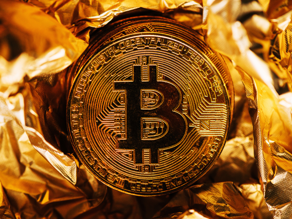Золотая монета биткоин на фольге