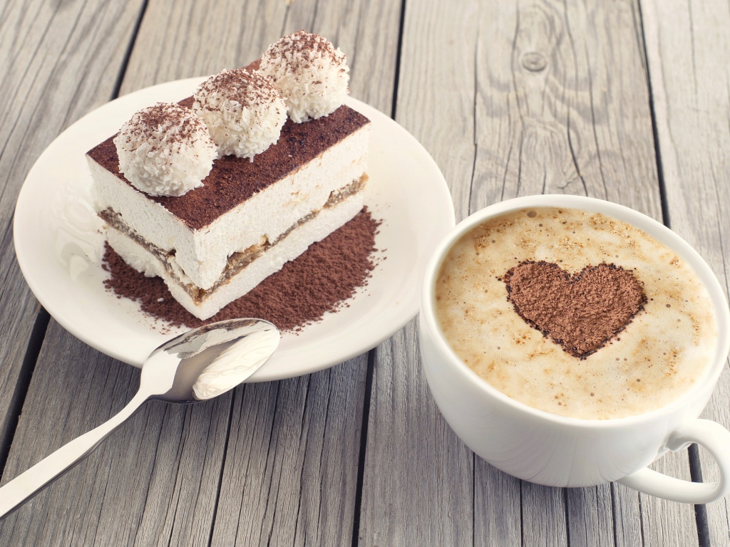 Чашка капучино с пирожным на столе 