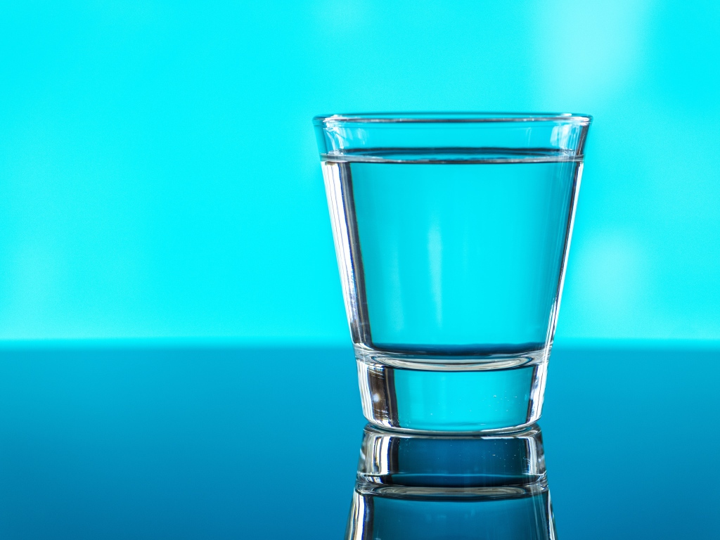 Стакан воды на голубом фоне 