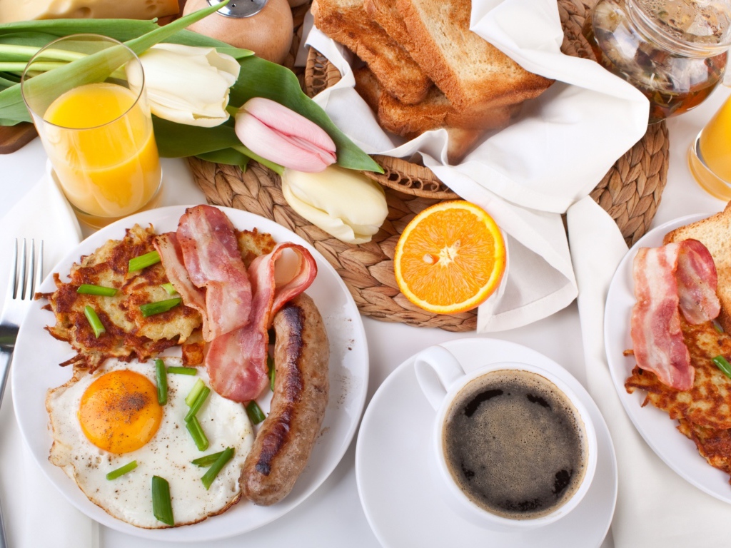 Сытный завтрак на столе с букетом тюльпанов 