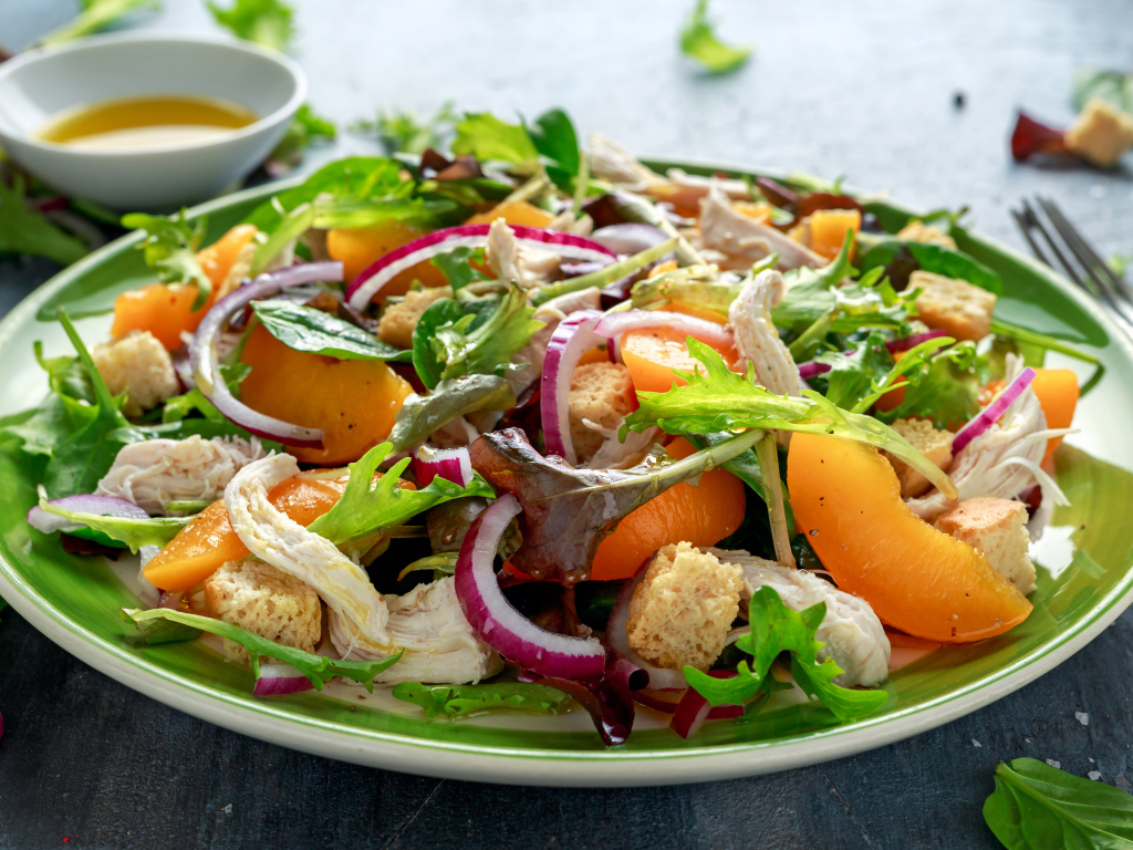 Аппетитный салат с курицей на большой тарелке