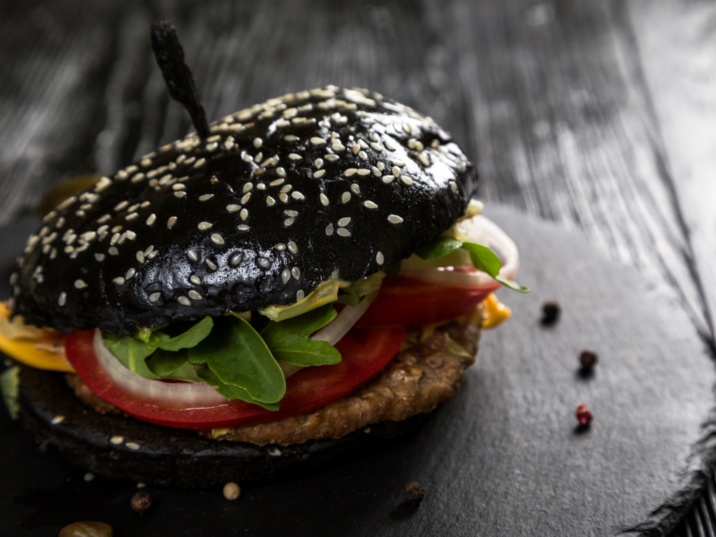 Черный гамбургер на столе